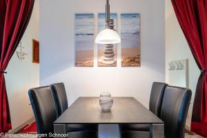a dining room with a table with chairs and a lamp at Ankerplatz 607 in Schilksee