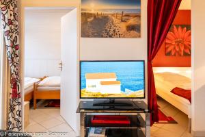 a television in a room with a bedroom at Ankerplatz 607 in Schilksee