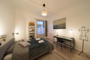 a bedroom with a bed and a desk in it at AppartUnique - Chez Klein - Balcon, Lumineux & Spacieux in Vichy