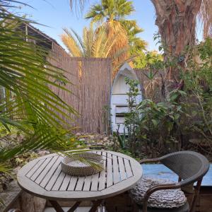 a table and chairs in a garden with a fence at Risan Chill in Eilat