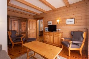 a living room with a table and chairs and a tv at Mörtbauerhof und Haus Frühauf in Seeboden