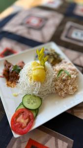 a plate of food with noodles and vegetables on a table at MOYE MOYE Ella in Ella +41 photos