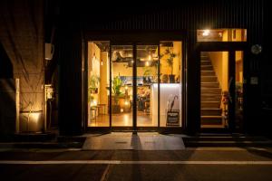 a store front at night with its doors open at Ryokan Suzuri 旅館 すずり in Tokyo