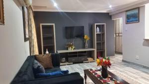 a living room with a couch and a tv at The Palace in Pretoria