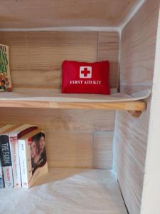 a book shelf with a red first aid kit on it at "Village Aris" Sevasti Symi Studios in Symi +4 photos