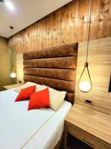 a bedroom with a bed with two red pillows at Hotel Tushar Elegant in Ghaziabad