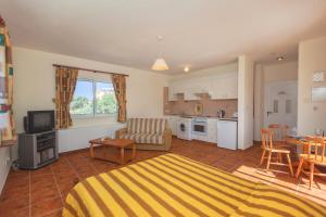 a living room with a bed and a kitchen at Thekla Court in Polis Chrysochous