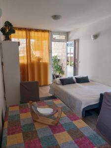 a living room with two beds and a table at Guest House Oscar near the Sea and river in Mokošica