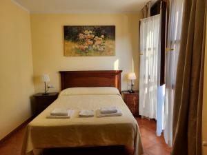 a bedroom with a bed with two towels on it at Casa Pelayin in Cue