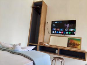 a bedroom with a flat screen tv on a wall at Alden Beach House in Sekotong