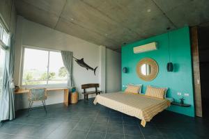 a bedroom with a bed and a green wall at Balay Kalachuchi in Barili