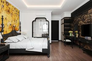 a bedroom with a large bed and a desk at Đại Cồ Việt Hotel Ninh Bình in Kỳ Vĩ