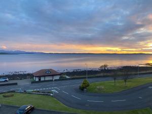 a view of a road with a building and the ocean at View of the Isles 2 in Largs