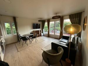 a living room with a couch and a table and chairs at Cabanes flottantes et gîtes au fil de l'eau in Colleville
