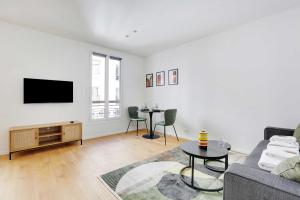 a living room with a couch and a tv and a table at Charming studio for 2P - near Parc Monceau in Paris