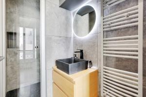 a bathroom with a sink and a mirror at Charming studio for 2P - near Parc Monceau in Paris