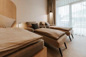 a bedroom with two beds and a couch and a window at Quartier 90 in Wietmarschen