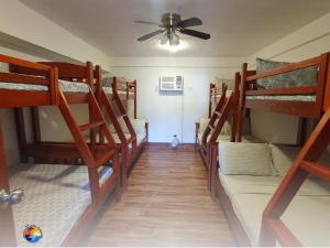 a room with four bunk beds and a ceiling fan at Appleton Little Paradise Beach Resort & Restaurant REAL QUEZON in Real +61 photos
