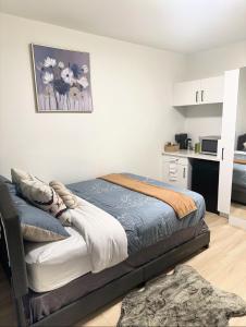 a bedroom with a bed and a kitchen at Quiet Private Room Victoria - PS5, Fast WiFi, Parking in Langford
