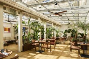 a restaurant with tables and chairs and potted plants at NH Collection Marbella in Marbella
