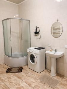 a bathroom with a washing machine and a sink at Apartments Domovik on Beregovskaya 3 in Mukacheve +55 photos