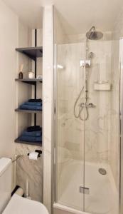 a bathroom with a shower with a glass door at Escale Alpine Appartement moderne avec parking proche Annecy et ski in Ugine