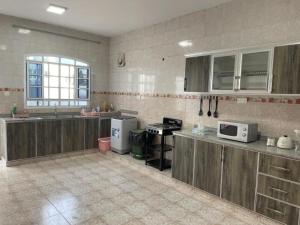a large kitchen with wooden cabinets and a microwave at Hostel Maral in Mawāliḩ