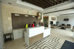 a kitchen and living room with a clock on the wall at Hotel Tushar Elegant in Ghaziabad