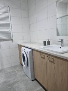 a bathroom with a washing machine and a sink at Apartament Marzeń 13 in Kostrzyn nad Odrą