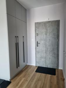 a large door in a room with wooden floors and white walls at Apartament Marzeń 13 in Kostrzyn nad Odrą