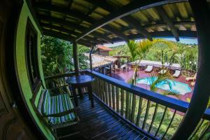a balcony with a view of a swimming pool at Pousada Aloha Beach House in Praia do Rosa