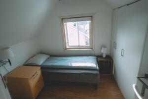 a small bedroom with a bed and a window at Chase Base Budget-Friendly Rooms in Tromsø