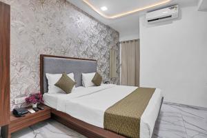 a bedroom with a large bed and a wall at Hotel New Star in Navi Mumbai +17 photos