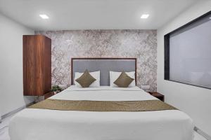 a bedroom with a large white bed and a screen at Hotel New Star in Navi Mumbai