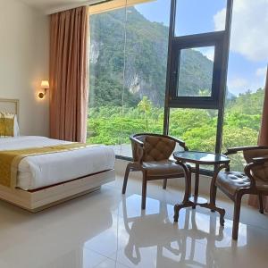 a bedroom with a bed and a large window at One El Nido Suite in El Nido