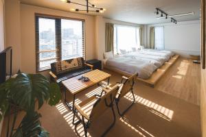 a bedroom with a bed and a table and chairs at wanderlust STAY in Kofu