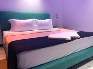 a bed with a green headboard and two white pillows at Sevmeth Villa in Kandy +17 photos
