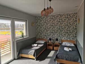 a bedroom with two beds and a window at Gościniec nad Olzą in Cieszyn