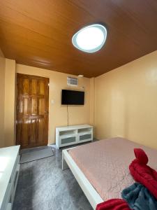 a bedroom with a bed and a flat screen tv at Appleton Little Paradise Beach Resort & Restaurant REAL QUEZON in Real