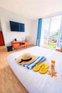 a bedroom with a bed with a hat and two flip flops at ibis Styles Le Havre Centre in Le Havre
