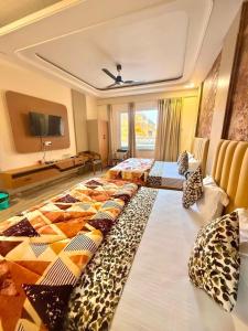 a hotel room with two beds with pillows on them at The Kridha Palace in Ayodhya