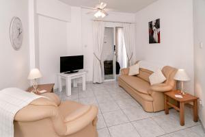 uma sala de estar com um sofá e uma televisão em Sue's Apartment em Pafos