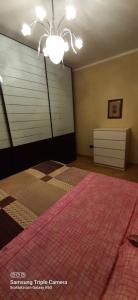 a bedroom with a large bed and a chandelier at I sogni di viola in Saluzzo