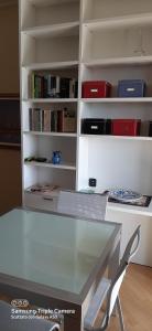 a glass table in front of a book shelf at I sogni di viola in Saluzzo