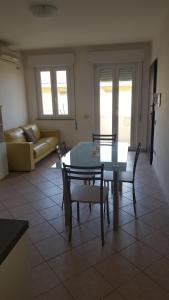 ein Wohnzimmer mit einem Tisch, Stühlen und einem Sofa in der Unterkunft Casa Vacanze Capoterra in Capoterra