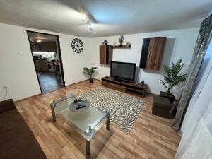 a living room with a coffee table and a flat screen tv at Apartment MBD in Veľká Mača
