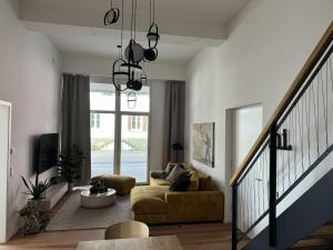 a living room with a couch and a staircase at Alte Feuerwache "nur wenige Minuten von Freiburg" in Hugstetten