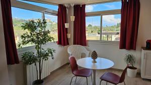 a table and chairs in a room with windows at B&B Triskèles in Giardini Naxos