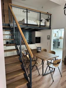 a kitchen and dining room with a spiral staircase and a table and chairs at Alte Feuerwache "nur wenige Minuten von Freiburg" in Hugstetten