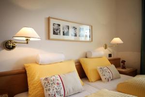 a hotel room with two beds with yellow pillows at Ciasa Rudiferia Appartamenti in Alta Badia in Badia